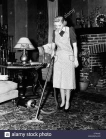 1930s-1940s-woman-housewife-wearing-apron-pushing-electric-vacuum-CTG1AE